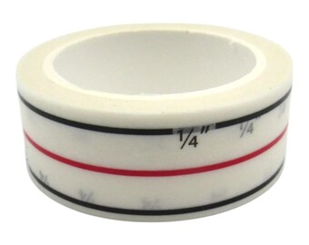 May include: A roll of white washi tape with black and red stripes and markings that include the fraction "1/4".