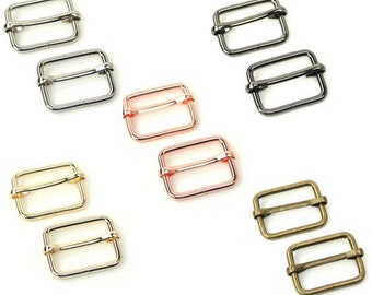 Op de afbeelding: Set van tien metalen schuifgespen in verschillende afwerkingen, waaronder zilver, zwart, rosé goud, goud en antiek messing. Elke gesp is rechthoekig met een gladde, afgeronde rand.