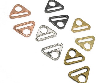 Puede incluir: Surtido de hebillas deslizantes de metal de forma triangular en varios acabados, incluyendo plata, oro, oro rosa y negro. Las hebillas miden aproximadamente 2,5 cm. EMMALINE HARDWARE.