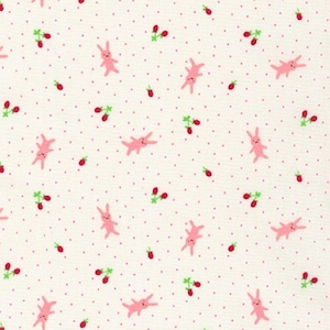 May include: A white fabric with a repeating pattern of pink bunnies and red berries. The background is a light cream color with tiny white dots.