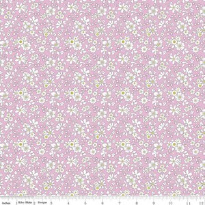 May include: A pink fabric with a white floral pattern. The flowers are small and have a yellow center. The fabric is perfect for quilting, sewing, and crafting.