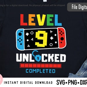 May include: A black t-shirt with a colorful graphic design that says "Level 9 Unlocked" with a progress bar that says "Completed". The graphic features a video game controller with a pixelated number 9.