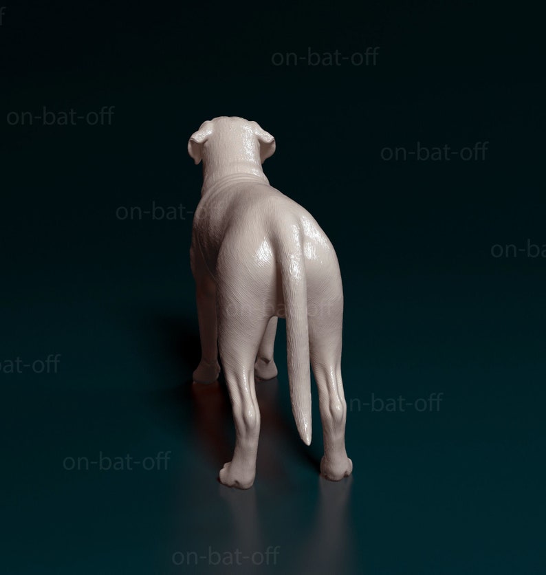 May include: A white ceramic dog figurine standing on a dark blue surface. The dog is facing away from the camera with its tail curled.