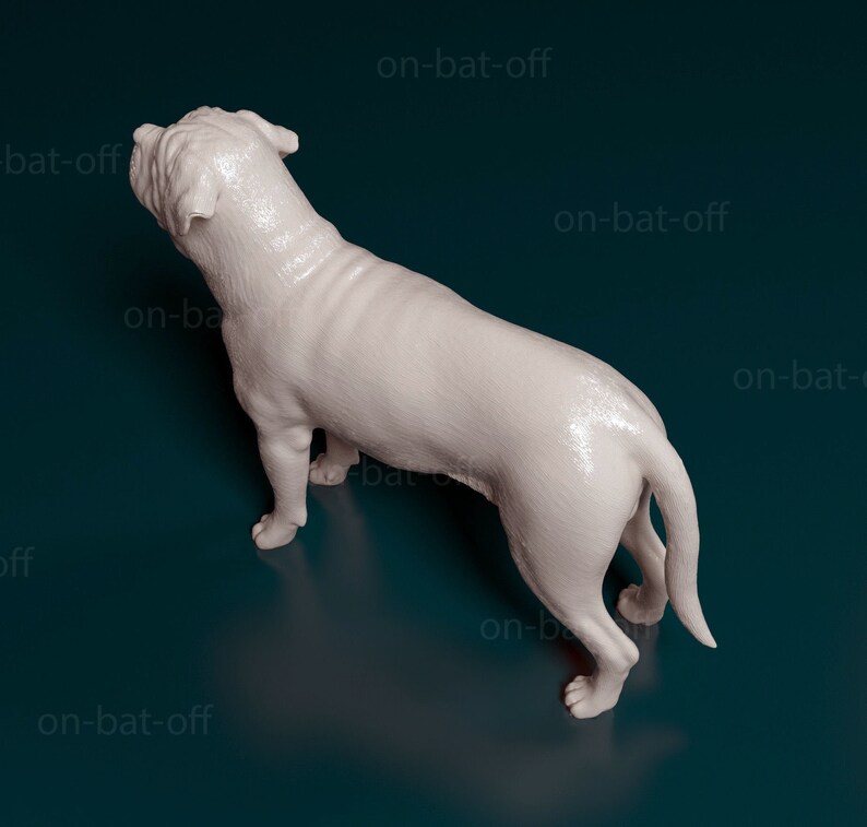 May include: A white, 3D printed dog figurine, viewed from above, with its tail curled to the side. The figurine is posed as if the dog is standing and looking to the left.