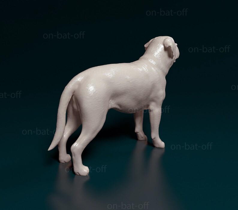 May include: A white ceramic sculpture of a dog standing on a dark blue surface. The dog is facing away from the camera and has its tail curled.