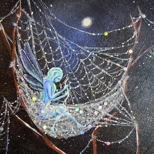 May include: A painting depicting a fairy seated in a shimmering spiderweb against a night sky filled with stars and a moon. The fairy is rendered in blue hues, with glitter detailing the web and the background.