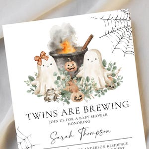 May include: A Halloween-themed baby shower invitation with the text "Twins Are Brewing." The design features watercolor illustrations of ghosts, pumpkins, a cauldron, and spiderwebs. The invitation includes event details and RSVP information.