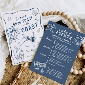 May include: Two invitation cards with a beach theme. One card has a blue illustration of a beach scene with text "Jamie's 50th Toast on the Coast". The other card is blue with event details. A gold wax seal is in the foreground.