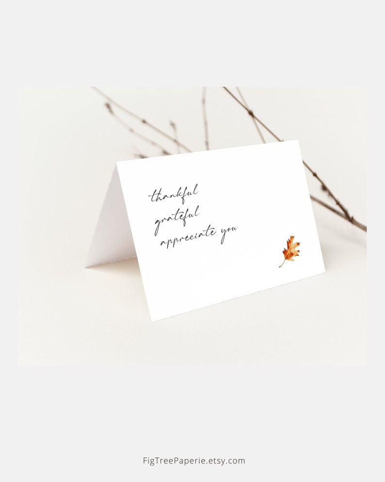 May include: A white card with the words "thankful grateful appreciate you" written in black cursive. A small brown leaf is in the bottom right corner.