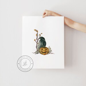 May include: A printable art print featuring a watercolor illustration of a black raven perched on a branch with a jack-o'-lantern. The background is white with a subtle texture. The print is from Fig Tree Paperie.