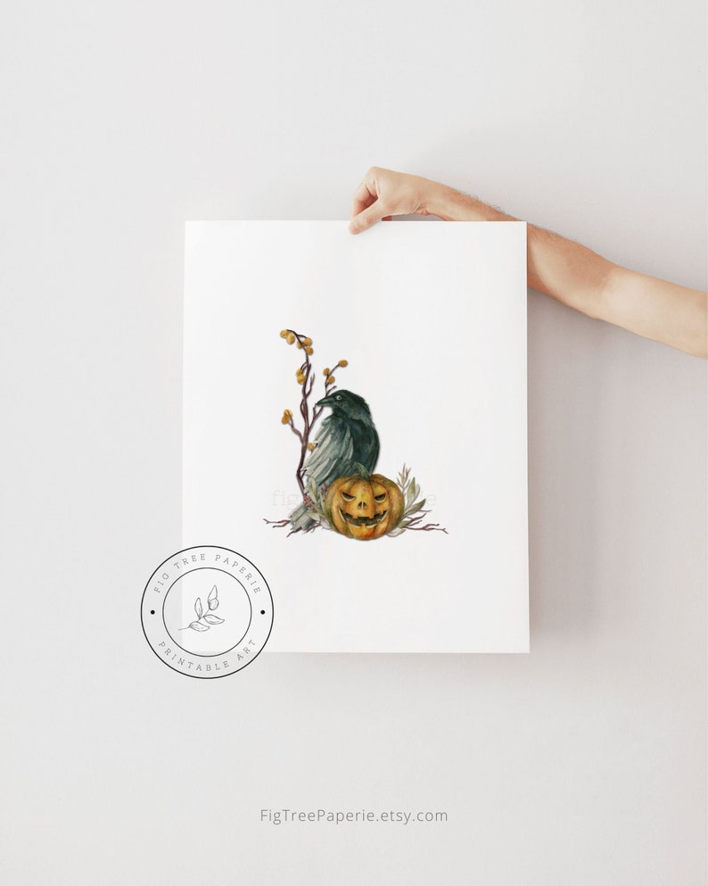 May include: A printable art print featuring a watercolor illustration of a black raven perched on a branch with a jack-o'-lantern. The background is white with a subtle texture. The print is from Fig Tree Paperie.
