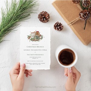 May include: A Christmas brunch invitation with a watercolor illustration of a mug of hot cocoa with marshmallows and a plate of pancakes. The invitation includes the date, time, and location of the event. RSVP information is also included.