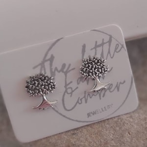 Op de afbeelding: Een paar zilveren boom oorbel studs op een witte kaart met de tekst "The Little Ear Co. Jewellery".