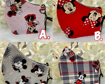 May include: Four different fabric face masks featuring Mickey Mouse and Minnie Mouse characters. The masks are in pink, red, gray, and plaid patterns. The masks are labeled A, B, C, and D.