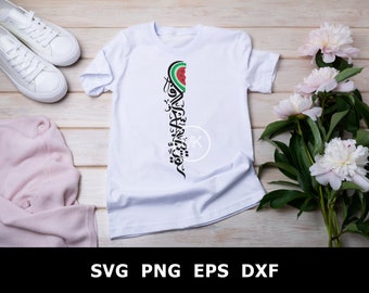 May include: White t-shirt with a black and green watermelon graphic and Arabic calligraphy text. The shirt is laid flat on a wooden surface with pink flowers and white sneakers.