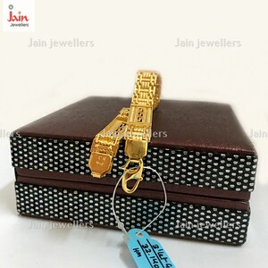 Puede incluir: Dos pulseras de oro con un dise&ntilde;o geom&eacute;trico, presentadas en una caja marr&oacute;n con un patr&oacute;n de lunares blancos. La caja tiene una etiqueta azul con el texto "B'let G 32.140 HM".