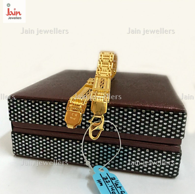 Puede incluir: Dos pulseras de oro con un dise&ntilde;o geom&eacute;trico, presentadas en una caja marr&oacute;n con un patr&oacute;n de lunares blancos. La caja tiene una etiqueta azul con el texto "B'let G 32.140 HM".