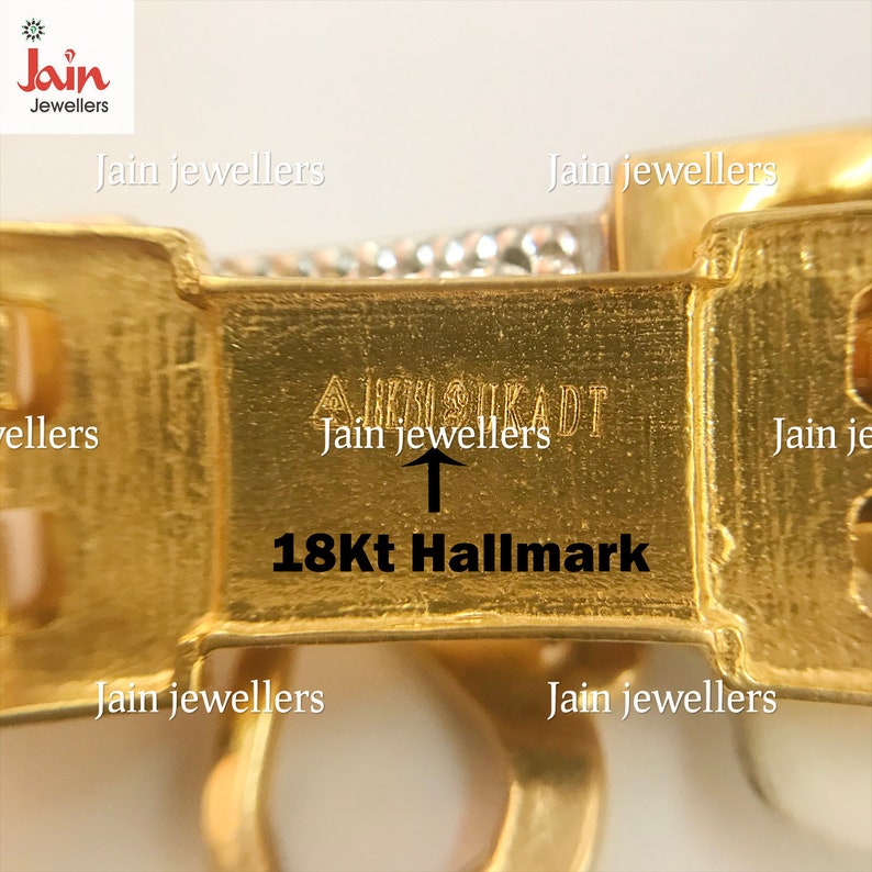 May include: Close-up of a gold bracelet with a 18Kt Hallmark and the inscription "Jain Jewellers" on the clasp.