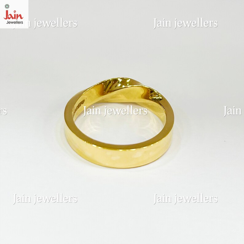 Puede incluir: Un anillo de oro con un dise&ntilde;o retorcido. El anillo es de color oro brillante y s&oacute;lido y parece estar hecho de un metal liso y pulido. El anillo est&aacute; sobre un fondo blanco.
