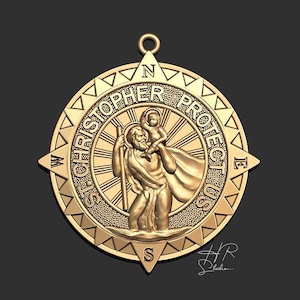 Op de afbeelding: Gouden hanger met een kompasontwerp met de woorden "St. Christopher Protect Us" rondom een afbeelding van Sint Christoffel die een kind draagt. De kompaspunten zijn gemarkeerd met N, S, E en W.