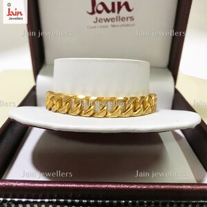 May include: A gold chain bracelet in a white box with the text "Jain Jewellers" on the box.