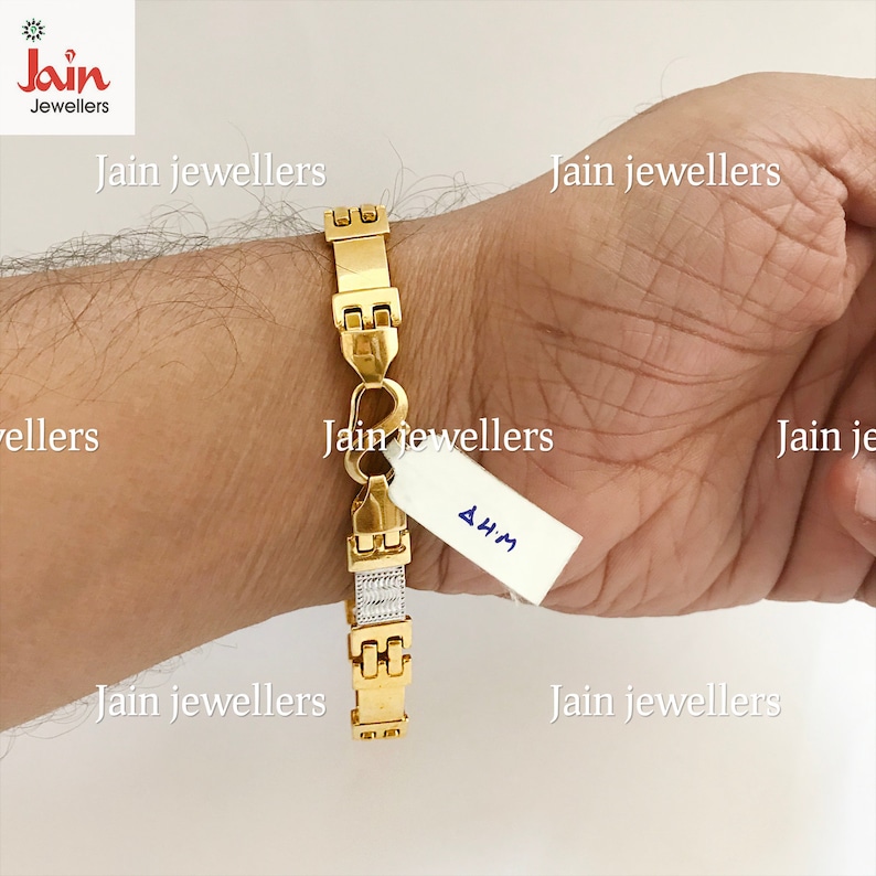 May include: A gold bracelet with a heart-shaped clasp and a diamond-like pattern on the band. The bracelet is 4.4M in size.