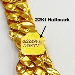 May include: A gold chain necklace with a 22Kt hallmark. The hallmark is stamped on a small tag attached to the chain. The tag reads "22K916 733E7V".