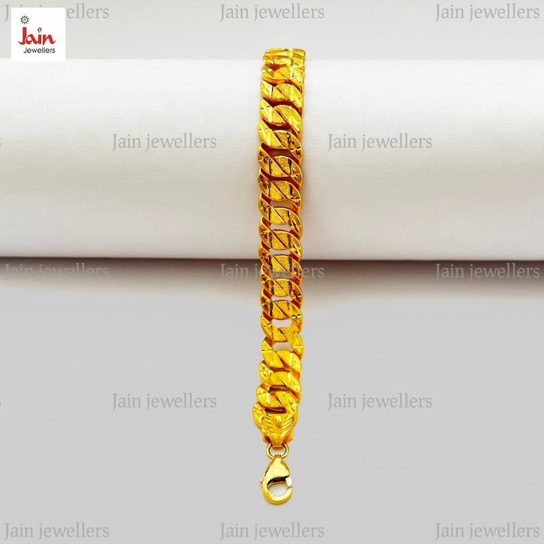 May include: A gold chain bracelet with a textured design. The bracelet has a clasp closure.