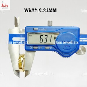 Puede incluir: Un calibrador digital mide un anillo dorado. La pantalla digital muestra un ancho de 6,31 mm. El calibrador es azul con texto blanco, y la imagen incluye el texto "Jain jewellers".