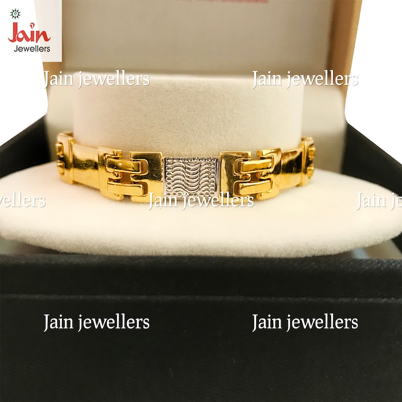 May include: A gold bracelet with a textured design. The bracelet is in a black box with the words "Jain Jewellers" printed on it.