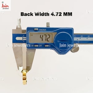 Puede incluir: Un calibrador digital que mide un objeto dorado. La pantalla muestra 4,72 mm, con el texto "Back Width 4.72 MM" arriba. El calibrador es azul con marcas blancas. La marca "Jain Jewellers" es visible.