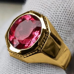May include: A gold ring with a large, octagonal, pink gemstone.