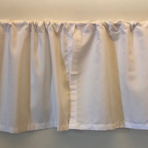 May include: A pair of white cafe curtains with a simple, gathered design. The curtains are hung on a white rod.