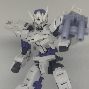 May include: A white and purple action figure robot with a weapon attached to its right arm. The robot has a detailed design with multiple articulated joints and a helmet. The figure is posed in a dynamic stance, suggesting action.