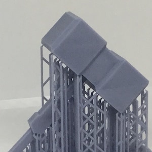 Könnte beinhalten: Ein 3D-gedrucktes Modell einer Struktur mit einem Gittersockel und drei übereinander gestapelten Würfeln. Die Würfel sind grau und das Gitter ist hellgrau.