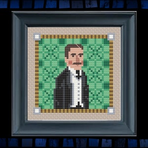 May include: A framed cross-stitch portrait of a man with a mustache wearing a black suit and white shirt against a green background.