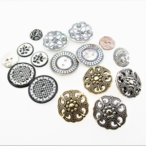 May include: Assortment of decorative buttons in various colors and patterns, including black and white, gold, and silver. The buttons feature intricate designs, such as floral motifs, geometric shapes, and swirls.