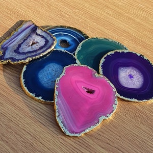 May include: Set of six agate coasters with gold trim. The coasters are in various shades of blue, purple, and pink.