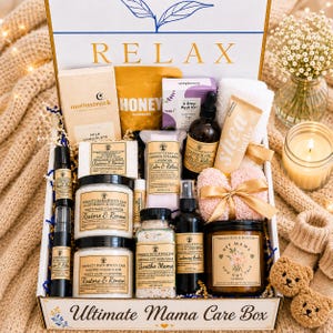 May include: A gift box labeled Ultimate Mama Care Box containing various bath and body products including a Moonstruck milk chocolate bar, honey pouch, lavender pedi kit, shea butter tube, massage oil, body lotion, sugar scrub, bath soak, linen spray, and a candle labeled Hey Mama You Got This.