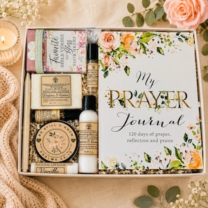 May include: A gift box containing a My Prayer Journal book, a bar of goat's milk soap, a bottle of body lotion, a soy candle, a vanilla lip balm, a perfume roller, and a small box of Favorite Bible Verses to Bless Your Heart cards.