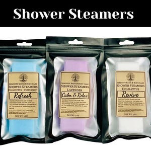 May include: Three shower steamers in individual clear plastic bags with black backing. The steamers are labeled "Refresh" with eucalyptus and peppermint, "Calm & Relax" with lavender, and "Revive" with eucalyptus. Each steamer is 3 oz.