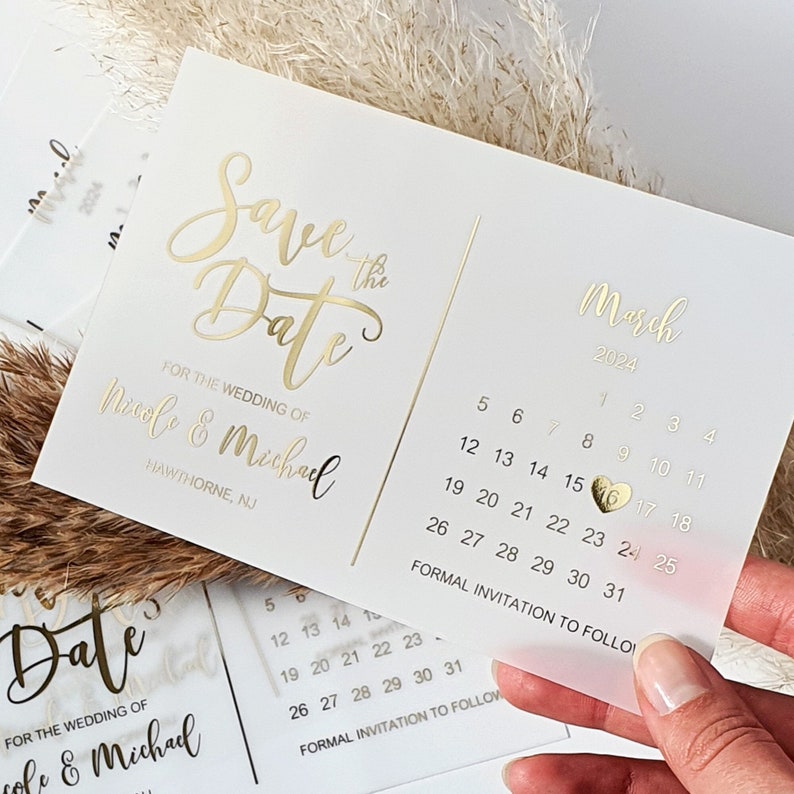 May include: Save the Date card with gold foil lettering for a wedding in March 2024. The card features a calendar with the date circled and a gold heart.