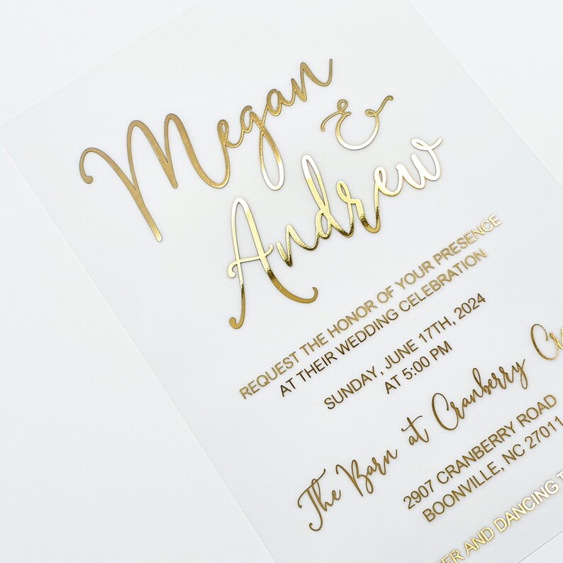 May include: Gold foil wedding invitation with the names Megan and Andrew, the date Sunday, 17th June 2024, and the location The Barn at Cranberry Creek, 2907 Cranberry Road, Boonville, NC 27011.