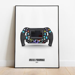 Könnte beinhalten: Ein schwarzes Lenkrad mit einem digitalen Display und verschiedenen Knöpfen und Schaltern. Das Lenkrad ist mit "AMG VOL3 1 PERFORMANCE CODE 413" beschriftet.