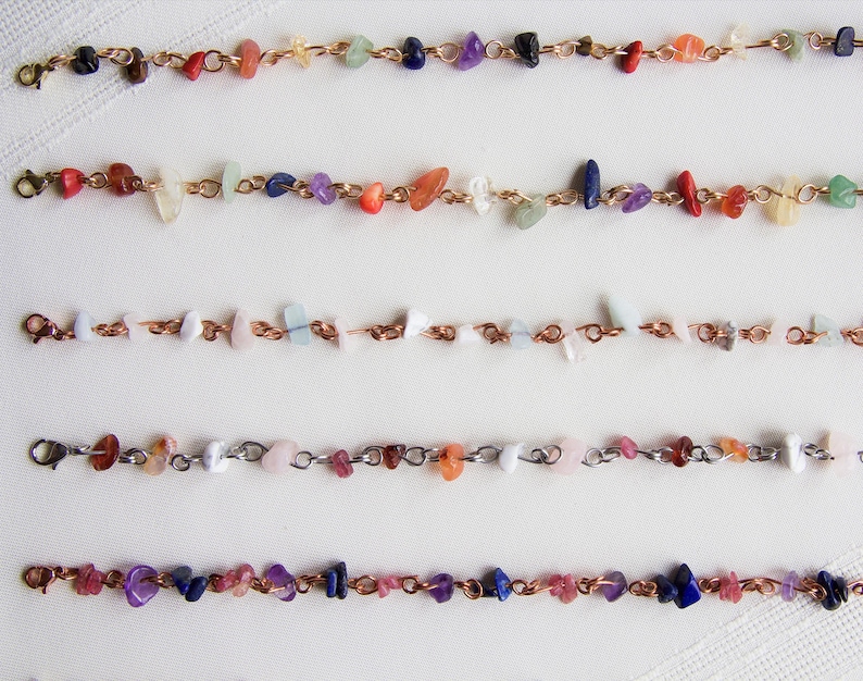 May include: Five copper chain bracelets with various colored gemstone beads. The bracelets feature a mix of pink, red, orange, yellow, green, blue, and purple beads.