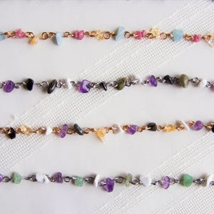 May include: Four strands of necklaces with various colored stones and metal chain links. The stones are small and appear to be natural.