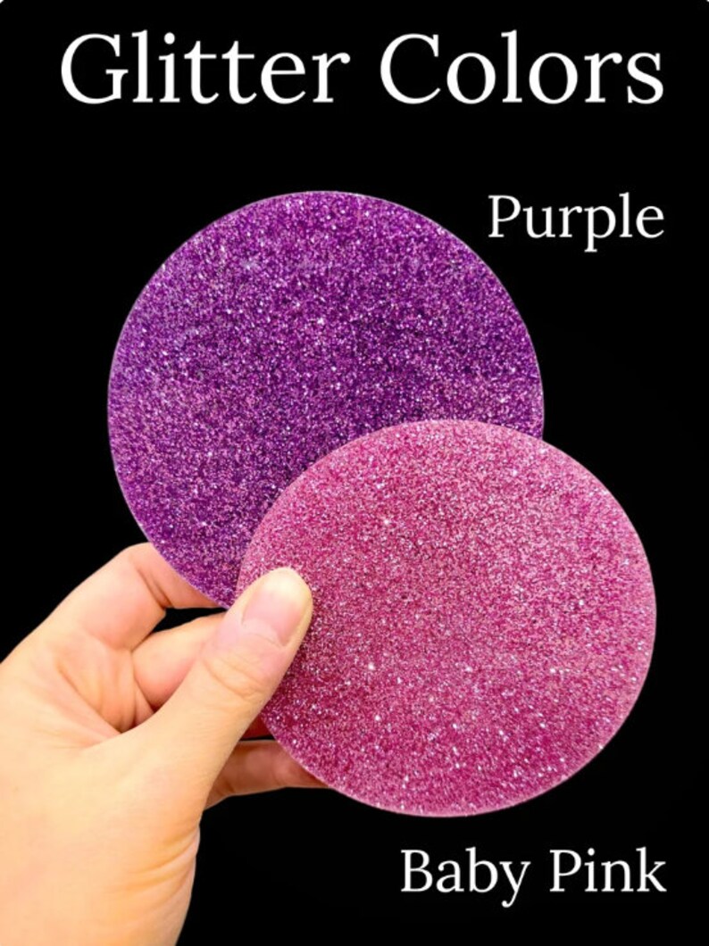 May include: The image displays two circular glitter samples against a black background. One is a vibrant purple, and the other is a soft baby pink. The text "Glitter Colors" and the color names are visible. The samples are held by a hand.