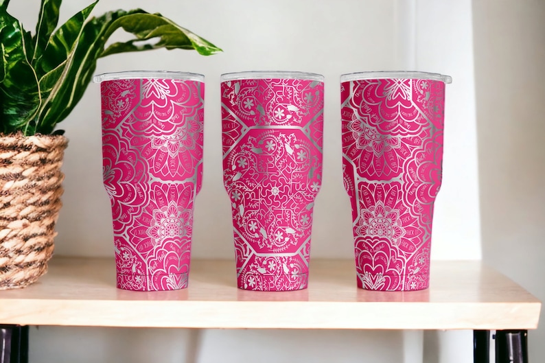 May include: Three stainless steel tumblers with a pink base and a silver mandala pattern.
