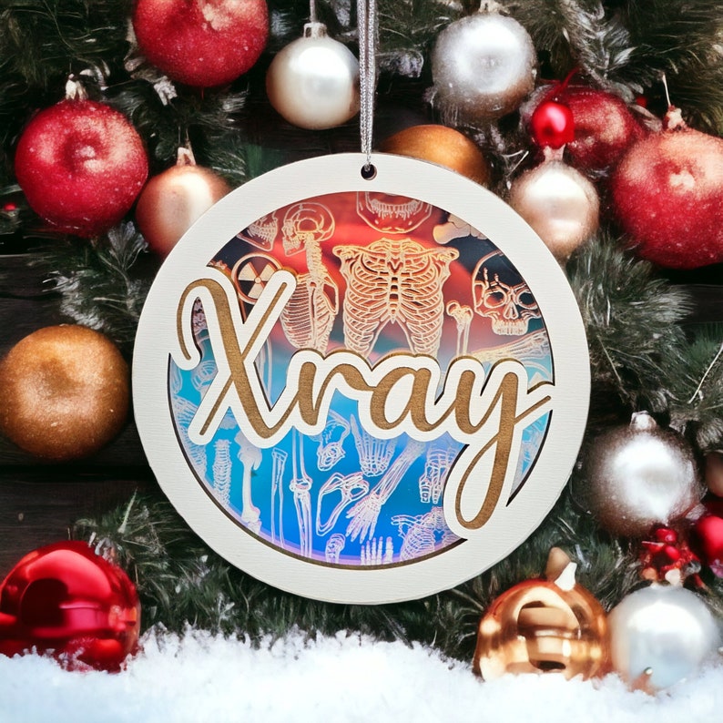 May include: A round Christmas ornament with the word "Xray" in a cursive font. The ornament features a layered design with a white outer ring and a detailed illustration of human skeletal anatomy. The background has a gradient of red and blue.
