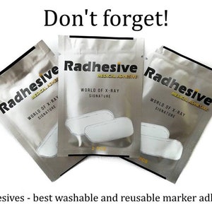 May include: Three silver metallic foil pouches labelled Radhesive Medical Adhesive World of X-Ray Signature. Each pouch features a graphic of two white rectangular adhesive pads and the text 2 PCS. The text Don't forget! and Radhesives - best washable and reusable marker adhesive appear above and below the pouches.